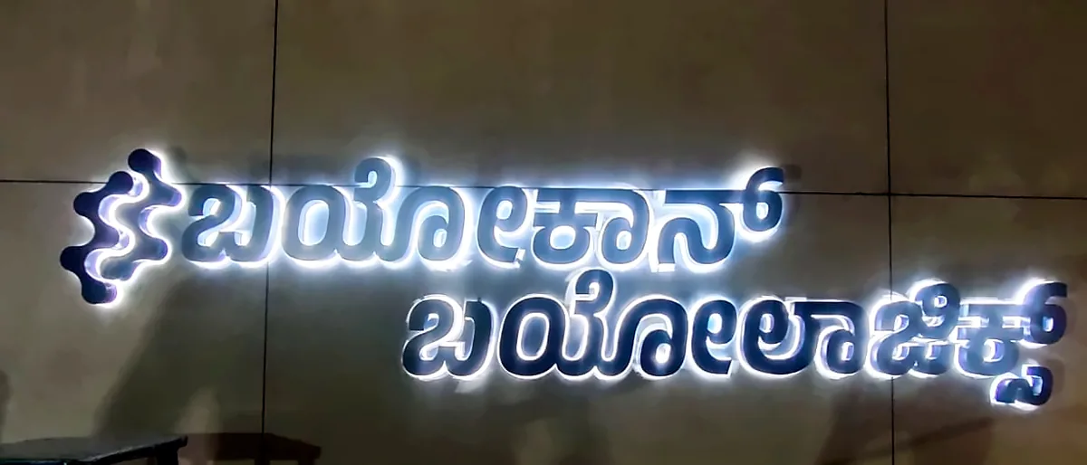 Halo-lit Kannada letters on a dark wall
