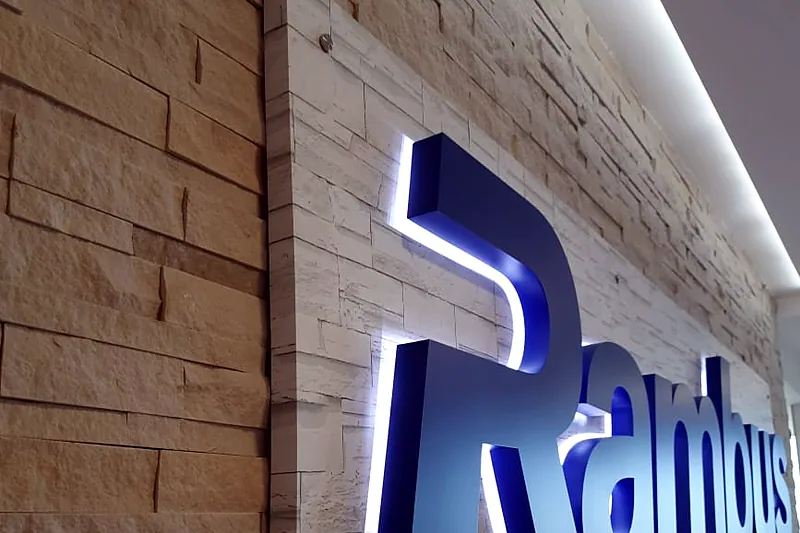 Halo-lit logo letters on a stone-clad wall